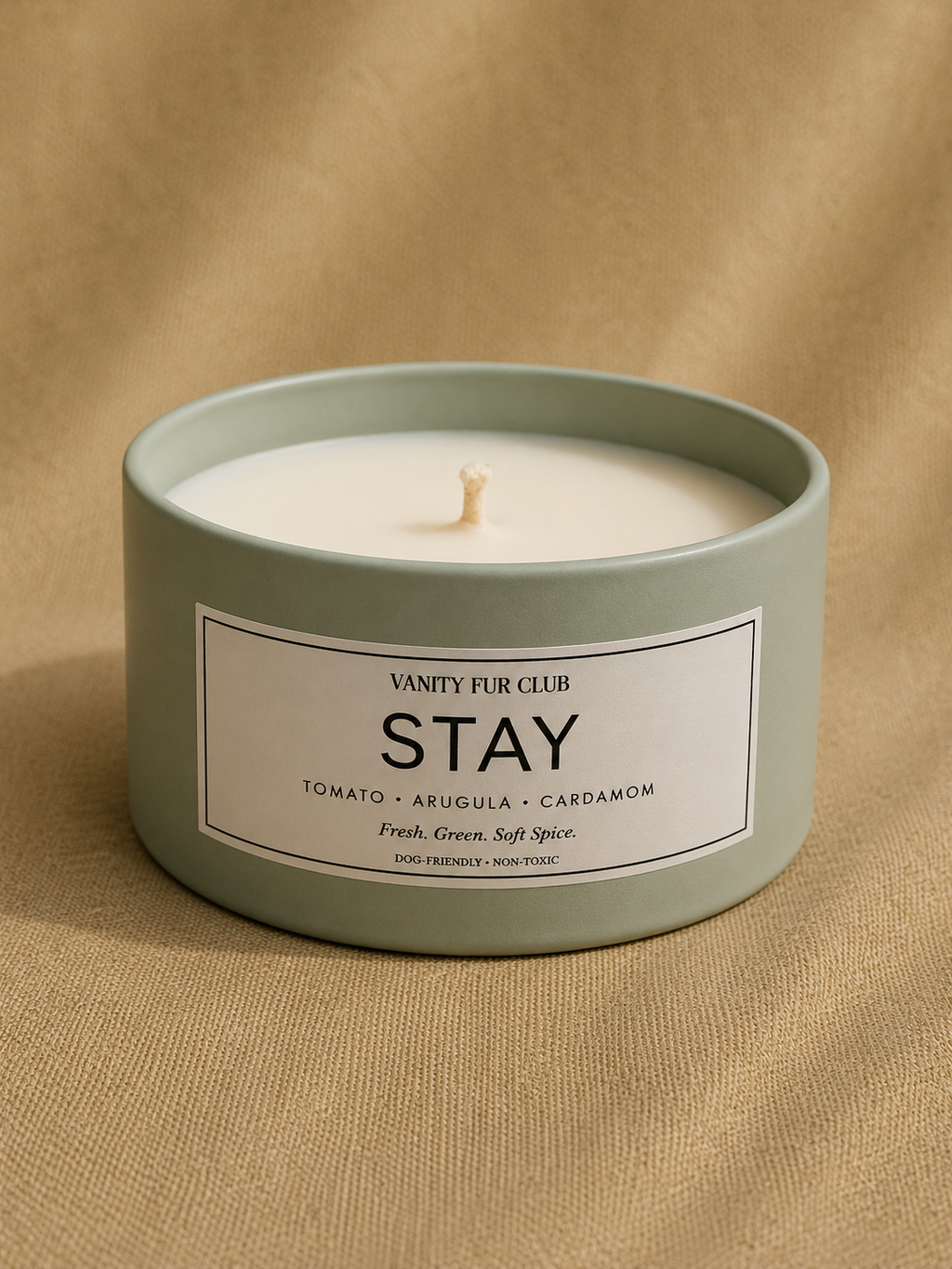 Candle in a green container with 'Vanity Fur Club' label on a beige background